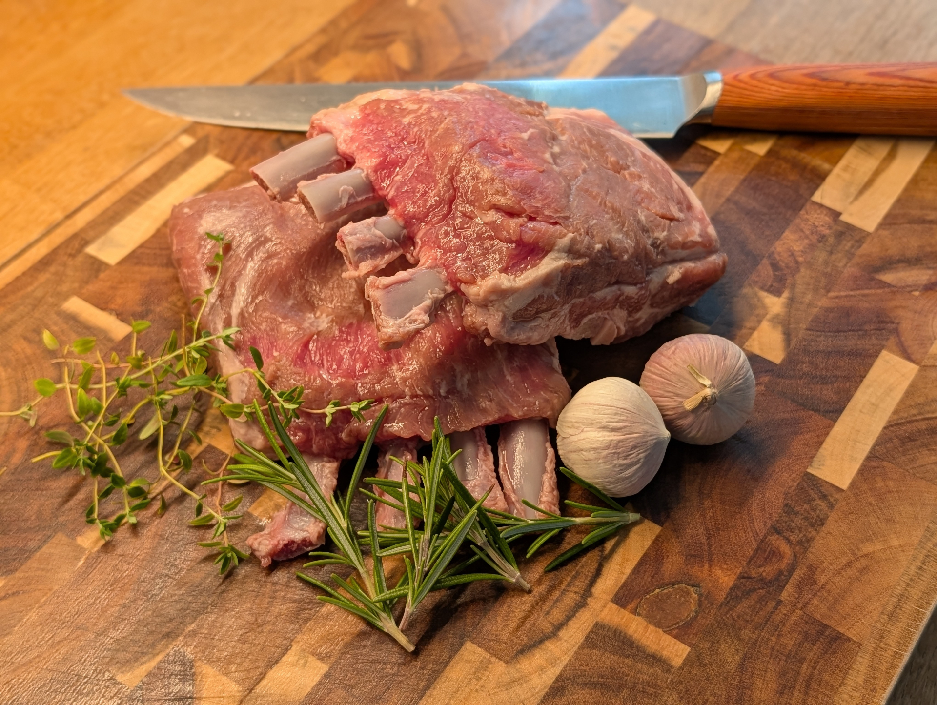 Råvaror på skärbräda – kött, vitlök och färska örter